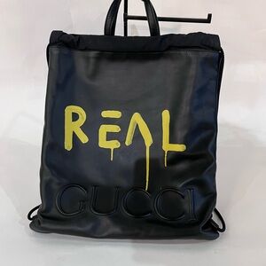Gucci Black Leather Drawstring Backpack with Yellow 'REAL' Graphic